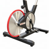 Rear view of a Keiser M3i indoor cycle, showcasing its iconic red rear-facing flywheel and sleek black V-shaped frame