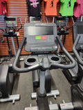 Ergonomic black Comfort Curve Plus seat on a Life Fitness stationary bike with a vertical ratcheting adjustment lever.