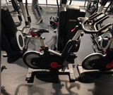 Detailed view of the multi-position ergonomic handlebars on a Life Fitness IC5 bike with the magnetic resistance dial and brake lever.