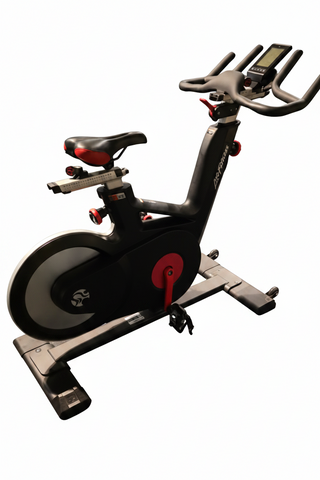 Profile view of the Life Fitness IC5 indoor cycle spin bike featuring a sleek black frame, red accents, and a rear-mounted aluminum flywheel