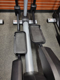 Side view of the Life Fitness Integrity INX commercial elliptical highlighting the rear-drive flywheel design and ergonomic moving handlebars
