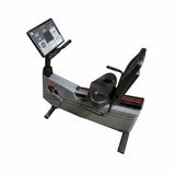 Full-length side profile of a silver and gray Life Fitness Lifecycle 9100 upright commercial exercise bike with an adjustable seat, racing handlebars, and a heavy steel frame base.