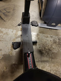 Close-up of the molded rubber multi-position handlebars on a Lifecycle 9100 upright bike, highlighting the deluxe padded forearm supports for racing positions.