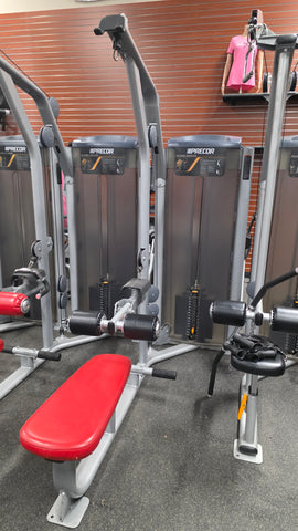 Close-up of the adjustable thigh hold-down pad and yellow pop-pin adjustment on the Precor Vitality Series dual back machine.
