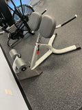 Star Trac IN-B7502 45 degree back extension showing fixed angle frame and adjustable ankle pad, targets glutes hamstrings low back, commercial grade used condition