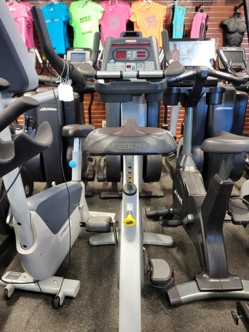 The adjustable ratchet seat mechanism on a silver Star Trac Pro exercise bike.