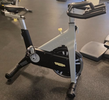  View of the micro-adjustable dual-density saddle and multi-grip PVC handlebars on the Technogym Group Cycle for optimal rider ergonomics.