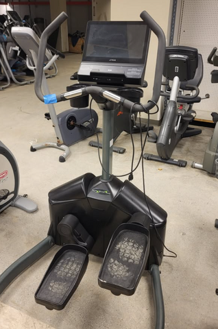  Commercial TRUE Fitness LateralX XS1000 lateral trainer machine featuring multi-grip handlebars, adjustable foot pedals, and an integrated UNITE touchscreen display on a gym floor.