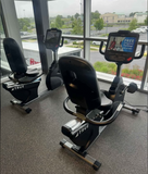 True Fitness R900 commercial exercise bikes with Unite 2.0 consoles lined up inside a modern fitness center.
