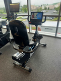 Close-up of the True Fitness Unite 2.0 touchscreen console display on an R900 exercise bike showing workout metrics and entertainment options.